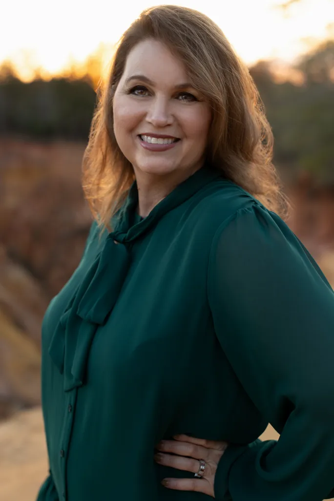 Tammy Nichols, owner and founder of That's a Wrap Acting Studio, smiling in a deep emerald blouse at golden hour